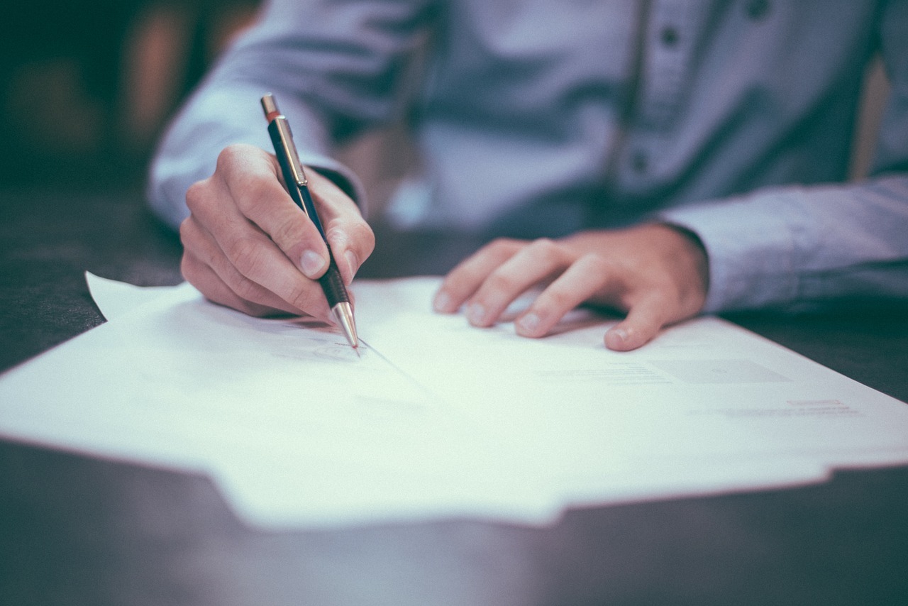 Image of man signing documents for Parole and Clemency